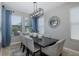 Bright dining room with modern light fixture, large windows, and seating for six at 12750 Tikal Way, Trinity, FL 34655