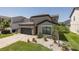 Inviting home exterior featuring a manicured front lawn, stone accents, and a well-kept garden at 12750 Tikal Way, Trinity, FL 34655