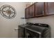 Modern laundry room featuring dark wood cabinets and updated washer and dryer at 12750 Tikal Way, Trinity, FL 34655