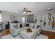 Comfortable living room with gray sectional, hardwood floors, ceiling fan, and guitars on the wall at 12750 Tikal Way, Trinity, FL 34655