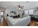 Comfortable living room with a large gray sectional sofa, hardwood floors, and a ceiling fan at 12750 Tikal Way, Trinity, FL 34655