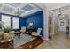 Stunning living room flows into the foyer with a blue accent wall and hardwood floors at 12750 Tikal Way, Trinity, FL 34655