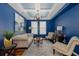 Stylish living room featuring blue walls, coffered ceiling, and elegant furnishings at 12750 Tikal Way, Trinity, FL 34655
