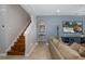 Cozy living room with staircase, modern light fixture, and a view of the backyard pool on the TV at 12750 Tikal Way, Trinity, FL 34655