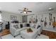 Comfortable living room with gray sectional, hardwood floors, ceiling fan, and guitars on the wall at 12750 Tikal Way, Trinity, FL 34655