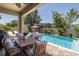 Covered patio seating area with a view of the beautiful pool and lush backyard landscaping at 12750 Tikal Way, Trinity, FL 34655