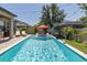 Inviting backyard pool featuring in-pool seating, umbrella, and lounge chairs for ultimate relaxation at 12750 Tikal Way, Trinity, FL 34655