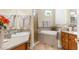 Bright bathroom with double vanity sinks, a walk-in shower, and garden tub at 13155 Cori Loop, Spring Hill, FL 34609