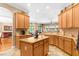 Kitchen features tile floors, wood cabinets, an island and open floorplan at 13155 Cori Loop, Spring Hill, FL 34609