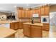 Spacious kitchen featuring an island, modern appliances, light wood cabinets, and neutral countertops at 13155 Cori Loop, Spring Hill, FL 34609