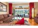 Cozy living room with hardwood floors, plush seating, and sliding glass doors overlooking a screened pool at 13155 Cori Loop, Spring Hill, FL 34609