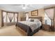 Spacious bedroom with a large window, a king-size bed, and soft carpet at 13155 Cori Loop, Spring Hill, FL 34609