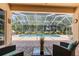 Inviting backyard with a sparkling pool enclosed in a screened patio, perfect for outdoor relaxation at 13155 Cori Loop, Spring Hill, FL 34609