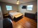 Comfortable bedroom featuring a ceiling fan, wood floors, and flat screen television at 13180 Lawrence St, Spring Hill, FL 34609