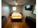 Cozy bedroom featuring a ceiling fan, wood floors, and flat screen television at 13180 Lawrence St, Spring Hill, FL 34609