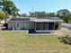 Rear view of the house featuring solar panels and a screened-in porch at 13180 Lawrence St, Spring Hill, FL 34609