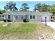 Charming single-story home featuring a well-manicured lawn, windows with white shutters and one-car garage at 13180 Lawrence St, Spring Hill, FL 34609
