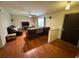 Living room with hardwood floors, ceiling fan, large window, and a comfortable leather sofa at 13180 Lawrence St, Spring Hill, FL 34609