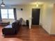 A spacious living room with hardwood floors, a ceiling fan, and a large window at 13180 Lawrence St, Spring Hill, FL 34609