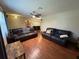Spacious living room with hardwood floors, ceiling fan, two leather sofas, and modern lighting at 13180 Lawrence St, Spring Hill, FL 34609
