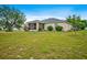 Lush backyard showcasing well-maintained green space and the rear of the home with a screened porch at 13317 Pinellas Ave, Spring Hill, FL 34609