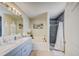 Bright bathroom featuring a double sink vanity, soaking tub, and tiled walk-in shower at 13317 Pinellas Ave, Spring Hill, FL 34609