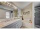 Bright bathroom featuring a double sink vanity, large mirror, and a separate tub and shower at 13317 Pinellas Ave, Spring Hill, FL 34609