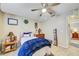 Cozy bedroom with a ceiling fan, wood-look floors, and a decorative wreath above the bed at 13317 Pinellas Ave, Spring Hill, FL 34609