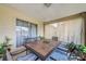 Covered patio with tiled table, comfortable seating, and a sliding glass door at 13317 Pinellas Ave, Spring Hill, FL 34609
