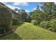 Green grass in the backyard, landscaped with trees, plants and foliage at 13460 Pia Ct, Spring Hill, FL 34609