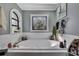 Relaxing bathroom featuring an oval soaking tub with decorative stained glass window and grey paint at 13460 Pia Ct, Spring Hill, FL 34609