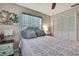 Comfortable bedroom features a decorative painting, ceiling fan, and large closet with louvred doors at 13460 Pia Ct, Spring Hill, FL 34609