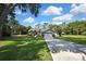 Charming single-story home with mature landscaping and a long driveway, nestled amidst lush greenery and blue skies at 13460 Pia Ct, Spring Hill, FL 34609