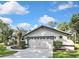 The house has a two-car garage with decorative accents and neatly trimmed bushes lining the walkway and driveway at 13460 Pia Ct, Spring Hill, FL 34609