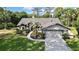This home features a two-car garage, meticulously landscaped grounds and an extended driveway lined with manicured bushes at 13460 Pia Ct, Spring Hill, FL 34609