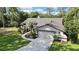 An aerial view of the garage shows manicured landscaping and a driveway, surrounded by lush greenery on a sunny day at 13460 Pia Ct, Spring Hill, FL 34609