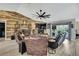 This is a cozy living room with a stone fireplace, wood accent wall, leather sofas, and a sliding door leading to the patio at 13460 Pia Ct, Spring Hill, FL 34609