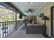 This covered patio has a comfortable seating area with a ceiling fan, and has views of the screened in pool at 13460 Pia Ct, Spring Hill, FL 34609