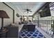 Relaxing screened-in patio with comfortable seating, ceiling fans, outdoor lighting, and black railing at 13460 Pia Ct, Spring Hill, FL 34609