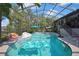 This beautiful pool features a screen enclosure, steps, a waterfall feature and fun pool toys at 13460 Pia Ct, Spring Hill, FL 34609