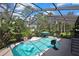 This beautiful pool features a screen enclosure, plenty of trees, and a blue umbrella at 13460 Pia Ct, Spring Hill, FL 34609