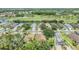 Expansive aerial view showcasing a neighborhood with mature trees, a pond, and a golf course at 1407 Hickory Moss Pl, Trinity, FL 34655