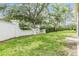 Well-maintained backyard featuring lush green grass and a sturdy white concrete perimeter fence at 1407 Hickory Moss Pl, Trinity, FL 34655