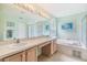 Bright bathroom featuring double sinks, a large mirror, a soaking tub, and a separate shower, offering a spa-like experience at 1407 Hickory Moss Pl, Trinity, FL 34655