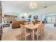 Open-plan dining area featuring neutral tones, a decorative chandelier, and access to the living room at 1407 Hickory Moss Pl, Trinity, FL 34655