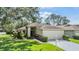 Charming single-story home with a well-manicured lawn, landscaping, and two-car garage at 1407 Hickory Moss Pl, Trinity, FL 34655
