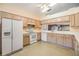 Functional kitchen featuring white appliances, wood cabinetry and ample counter space, ideal for everyday meal preparation at 1407 Hickory Moss Pl, Trinity, FL 34655