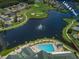 Aerial view of the pool and lake providing stunning views in the community at 1407 Hickory Moss Pl, Trinity, FL 34655