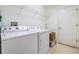Functional laundry room equipped with a washer, dryer, and overhead shelving for storage solutions at 1407 Hickory Moss Pl, Trinity, FL 34655