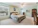 Serene main bedroom featuring a queen-sized bed, ceiling fan, and large window, creating a relaxing retreat at 1407 Hickory Moss Pl, Trinity, FL 34655